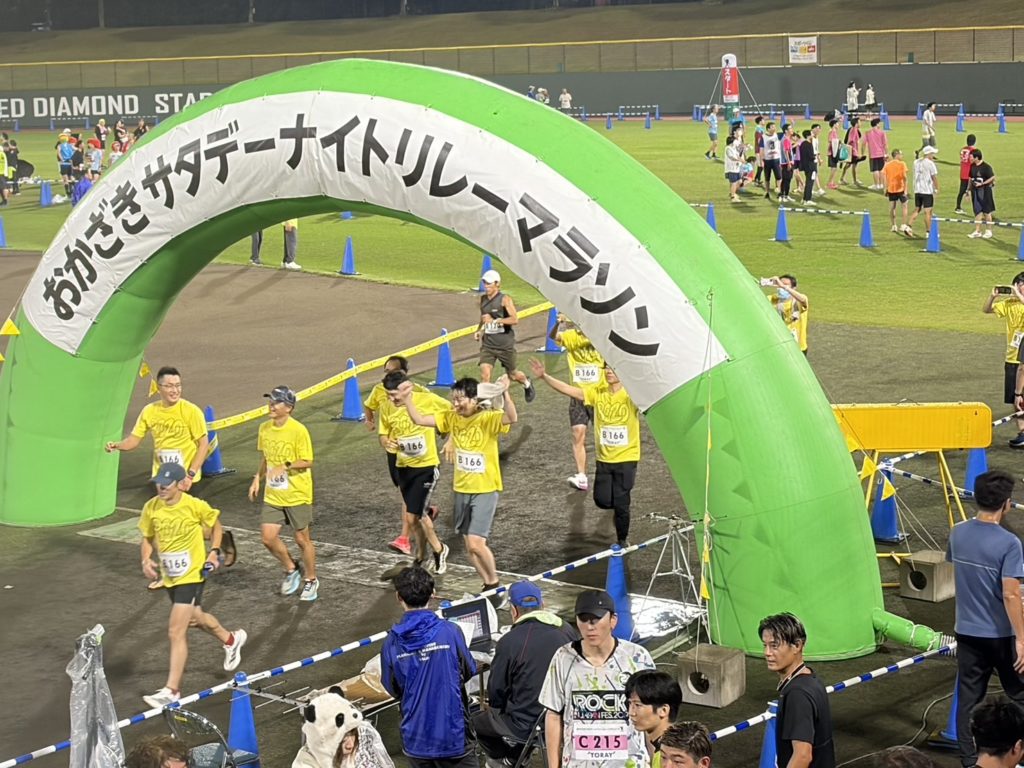 おかざきサタデーナイトリレーマラソンのゲートを走り抜けるチームメンバー